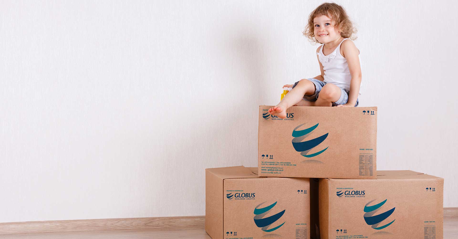 גלובוס, ילד יושב על קופסאות, רילוקיישן